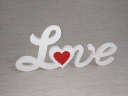 Napis Love stojący z czerwonym sercem